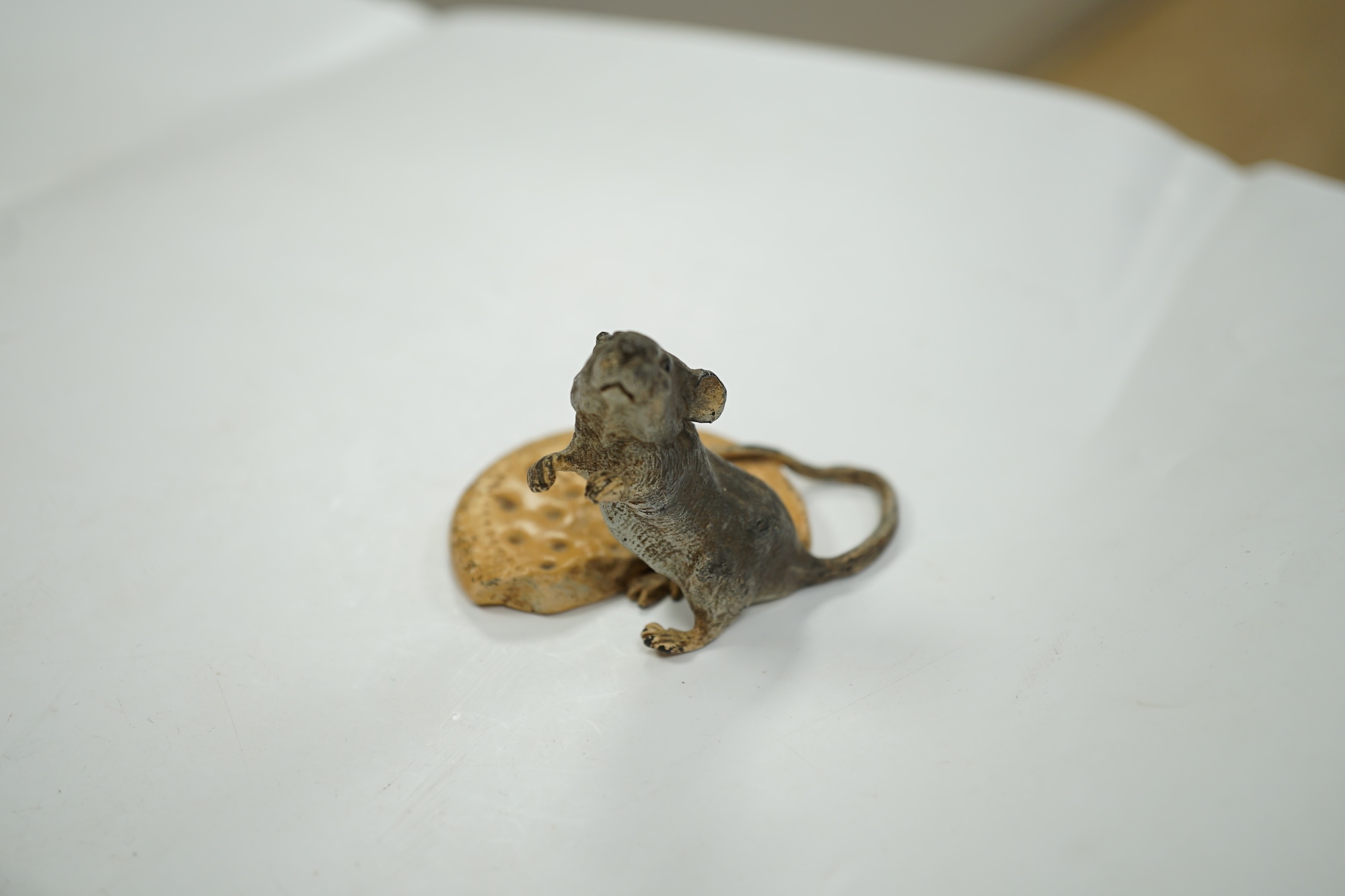 Franz Bergmann (1861-1936), a cold painted bronze study of a mouse and a biscuit, stamped marks to base, 5cm tall. Condition - fair